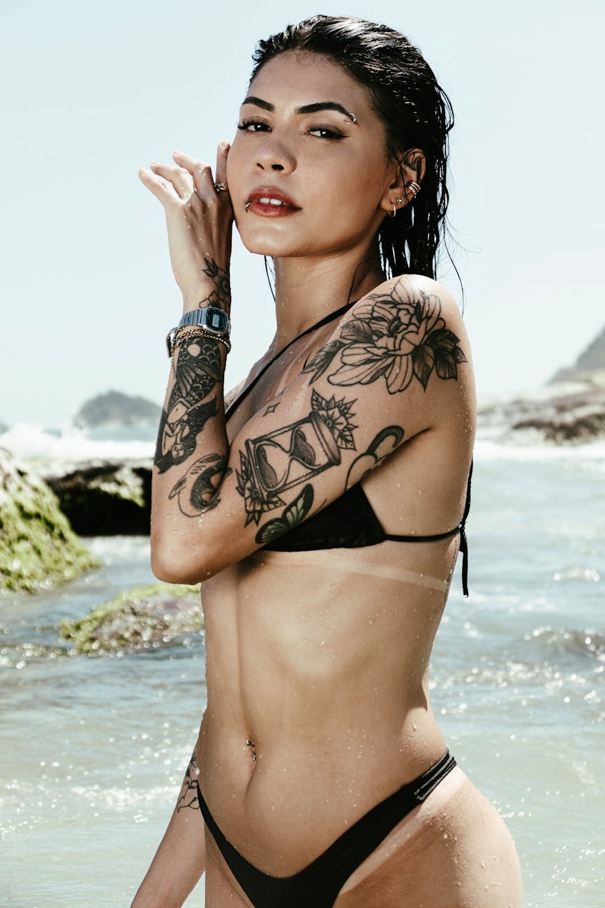 photo of a woman wearing a bikini with a tattoo on an arm
